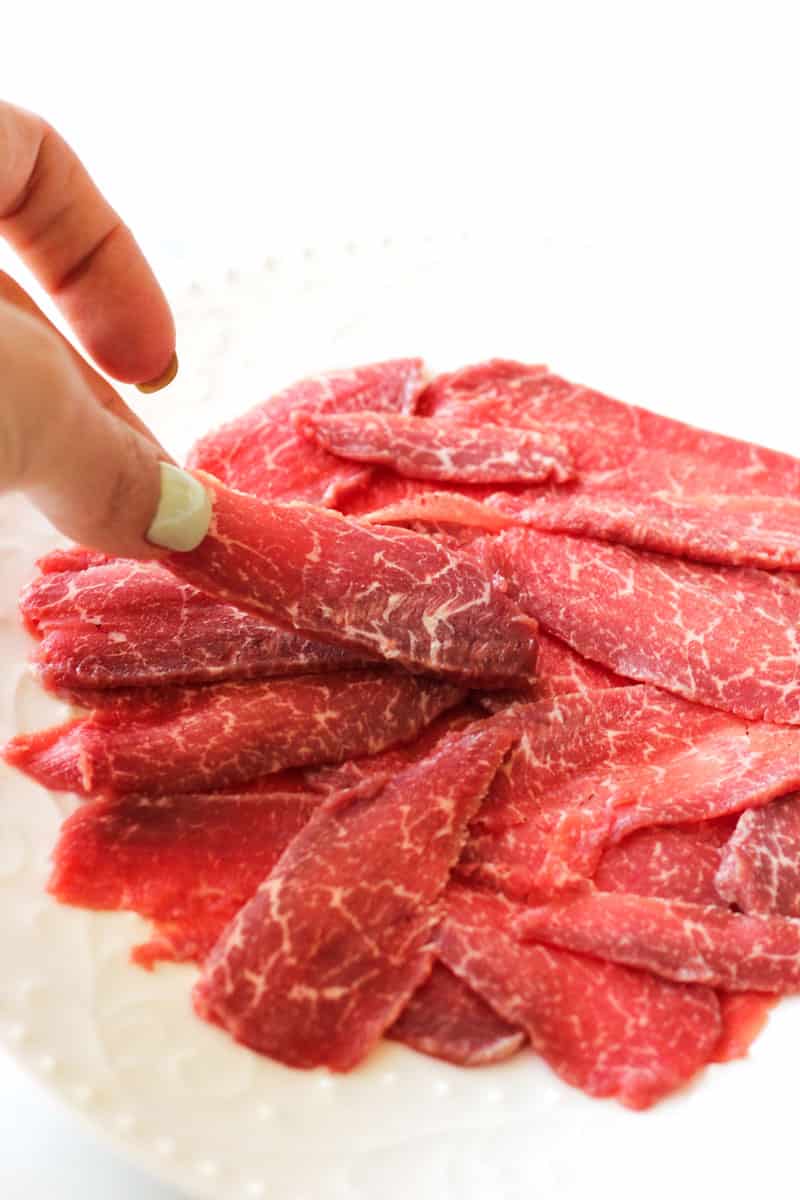 thinly sliced red meat in hand