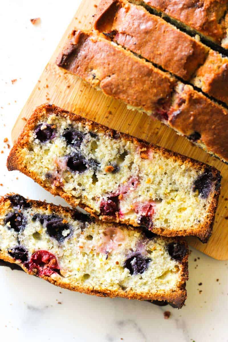 sliced cranberry blueberry bread on a cutting board