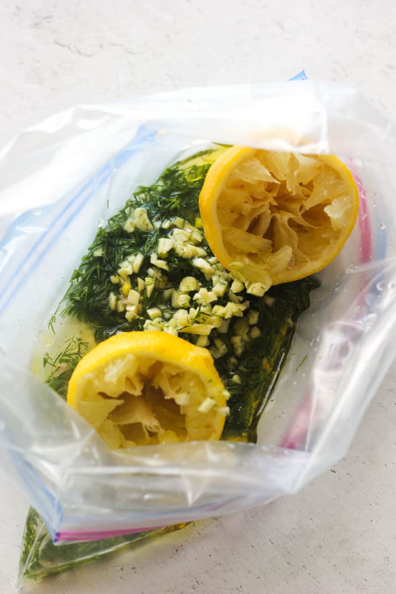 chopped dill, lemon halves and garlic in a ziplock bag