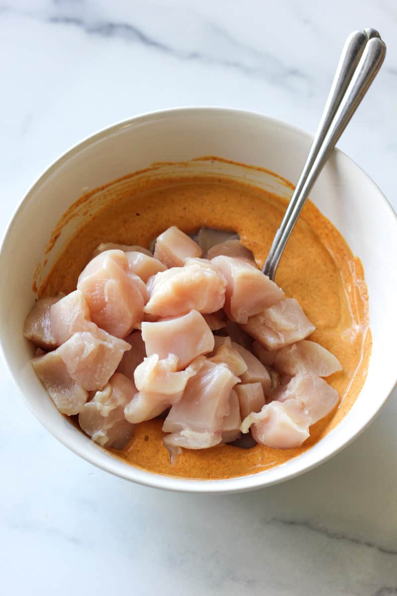 raw chicken breast cut in chunks on top of the sauce
