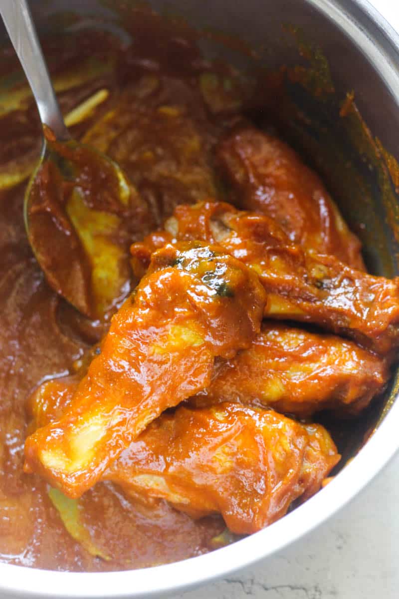 chicken wings covered in sauce in a pot