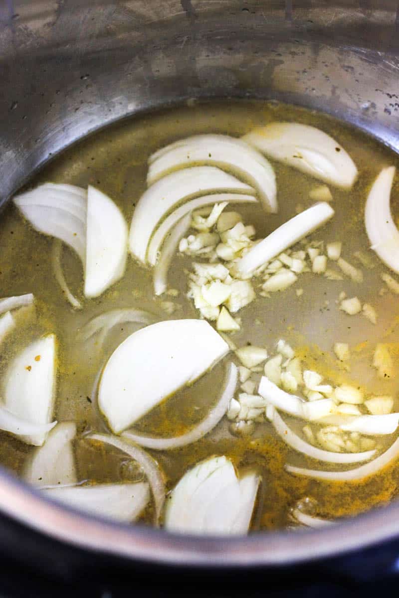chicken broth and onions in the pot