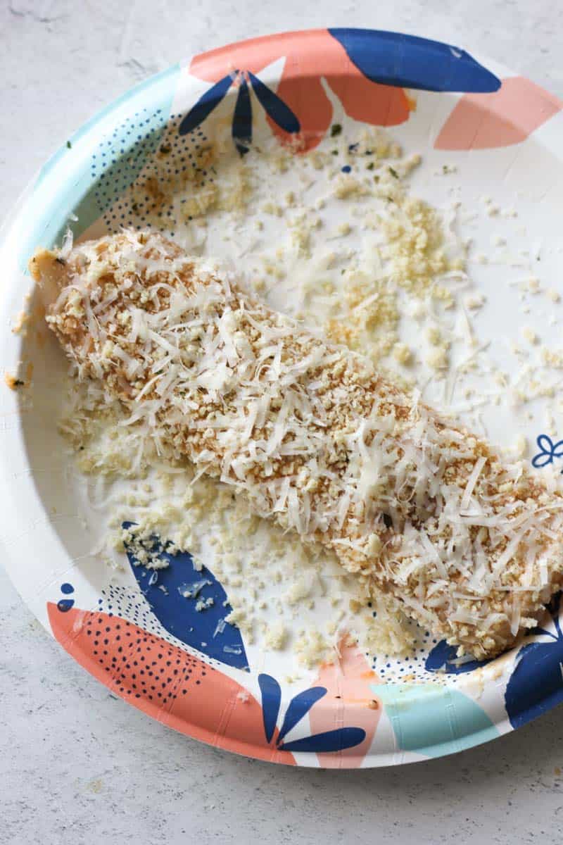 parmesan and panko crumbs covered walleye fish on the paper plate