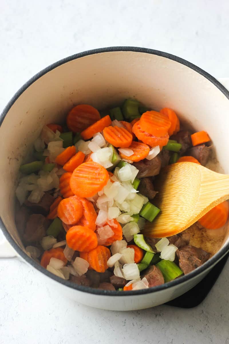 sauteing vegetables in a heavy bottom white pot
