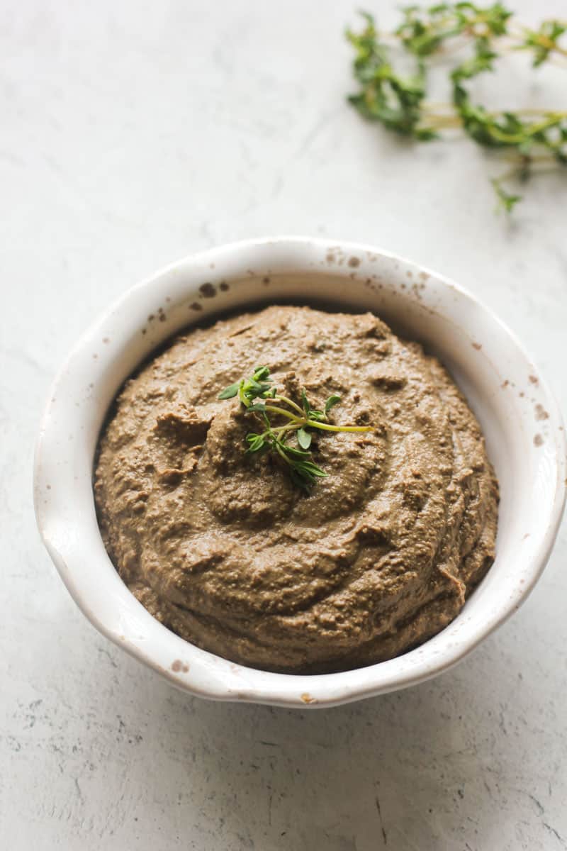 turkey liver pate in a small bowl with fresh thyme on top