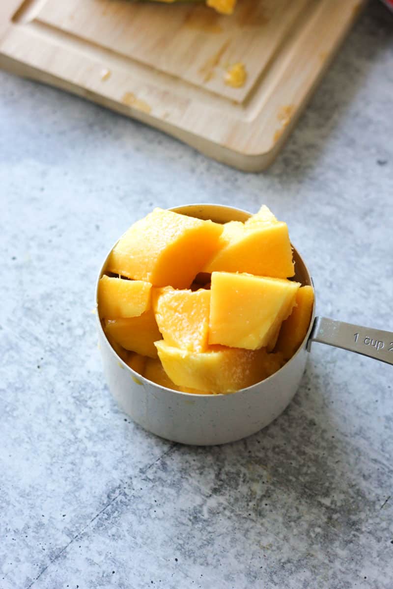 a cup of cubed mango on the table