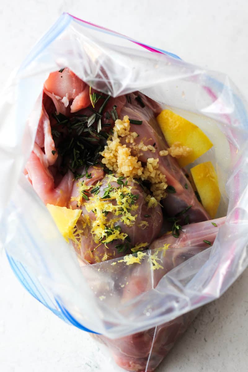 lemon zest, garlic and thyme on top of meat in the plastic bag