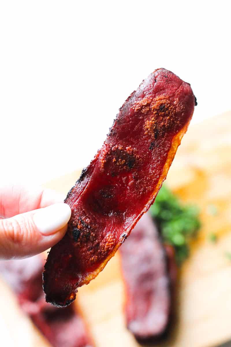 a piece of duck bacon in hand