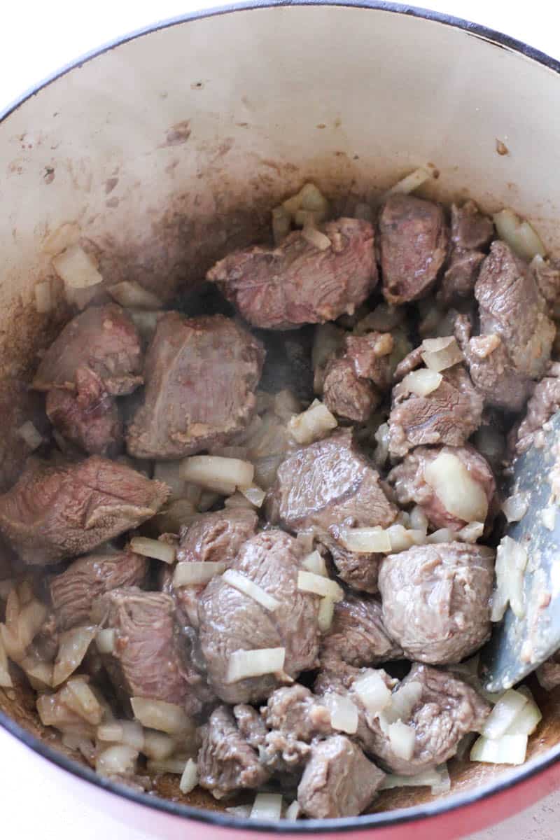 browning meat with onions in a pot