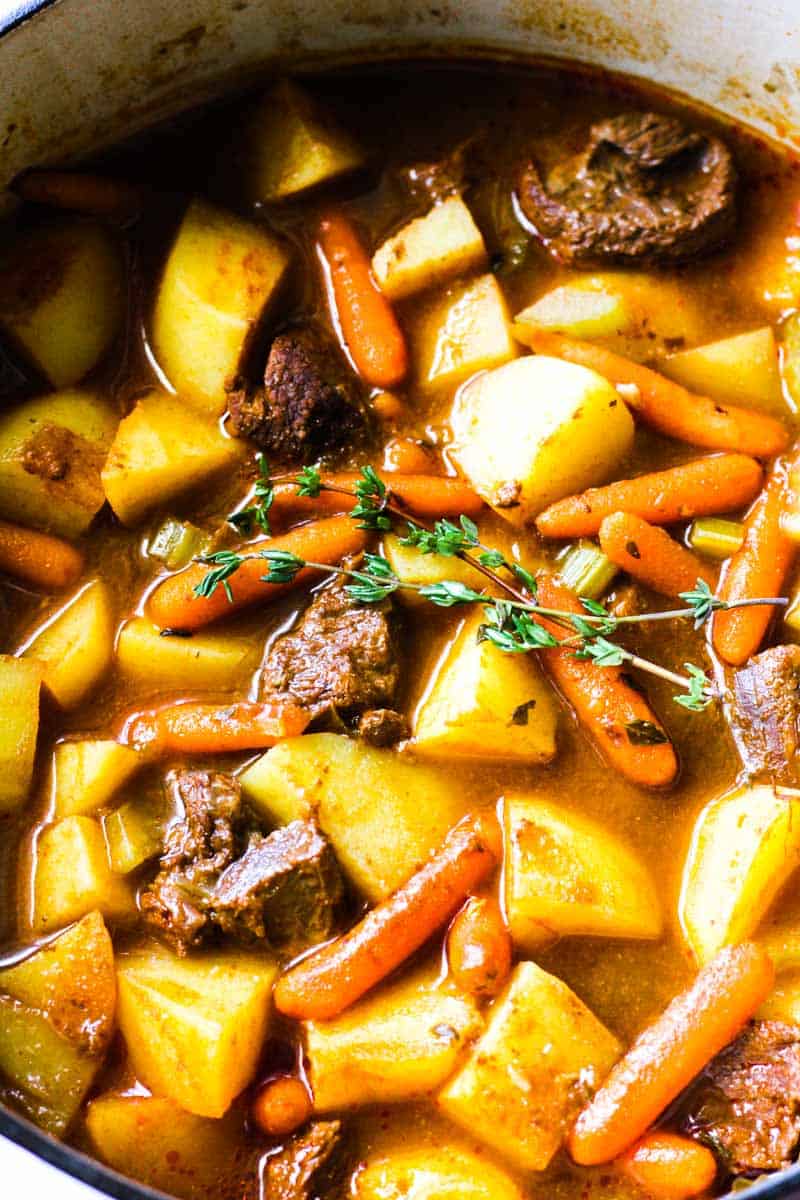 elk stew in a pot with potatoes, carrots and thyme