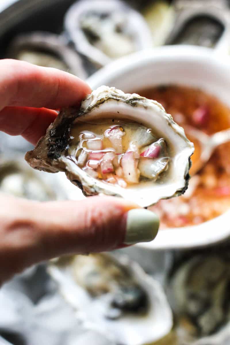 mignonette sauce on an oyster in hand