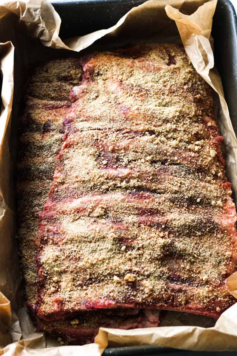 ribs in the baking dish covered with parchment paper
