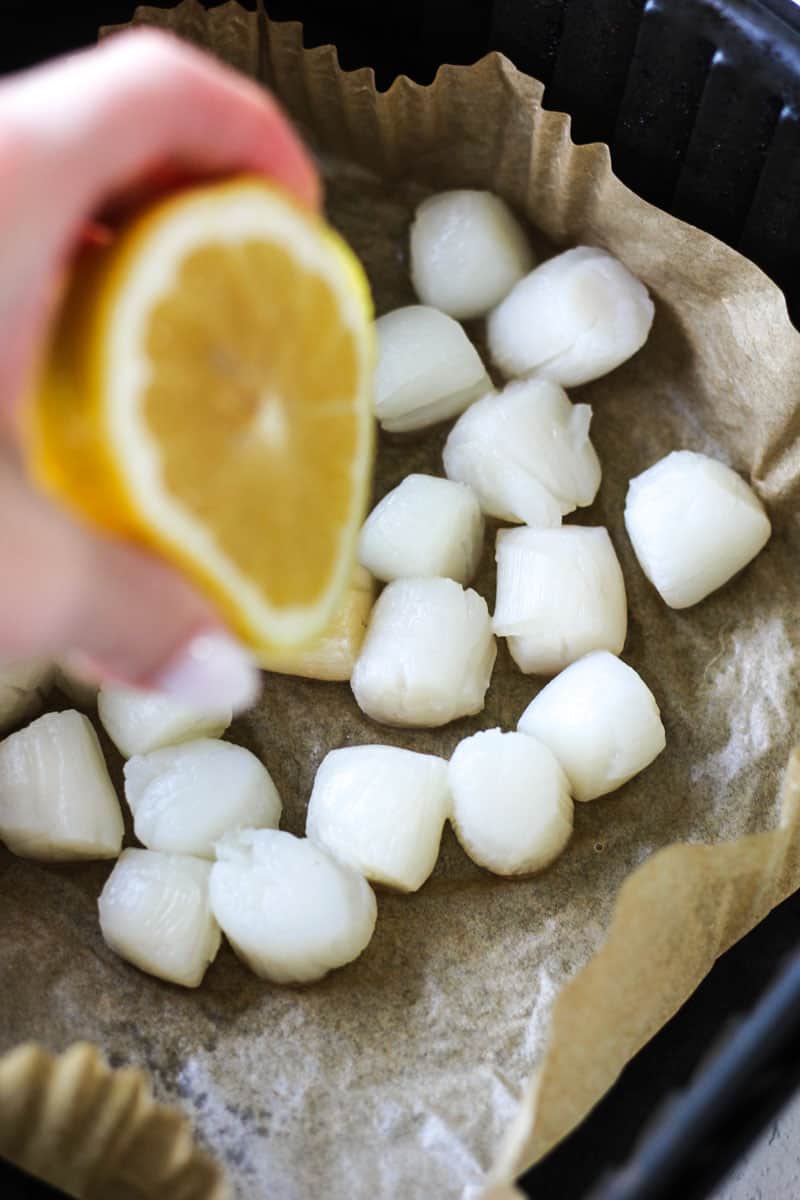squeezing some lemon on top of scallops