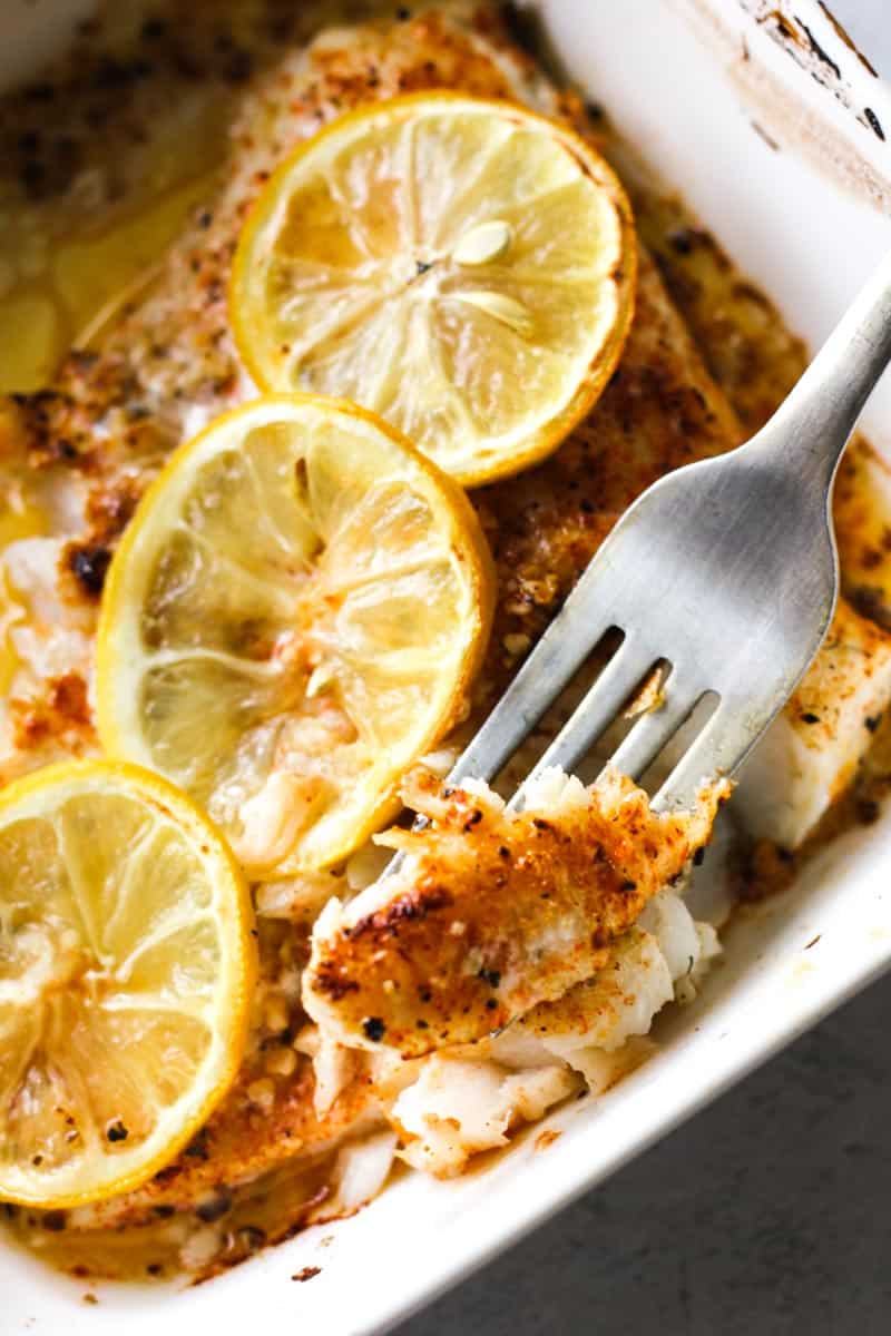 broiled walleye fillet with lemon, with a piece of fish on fork
