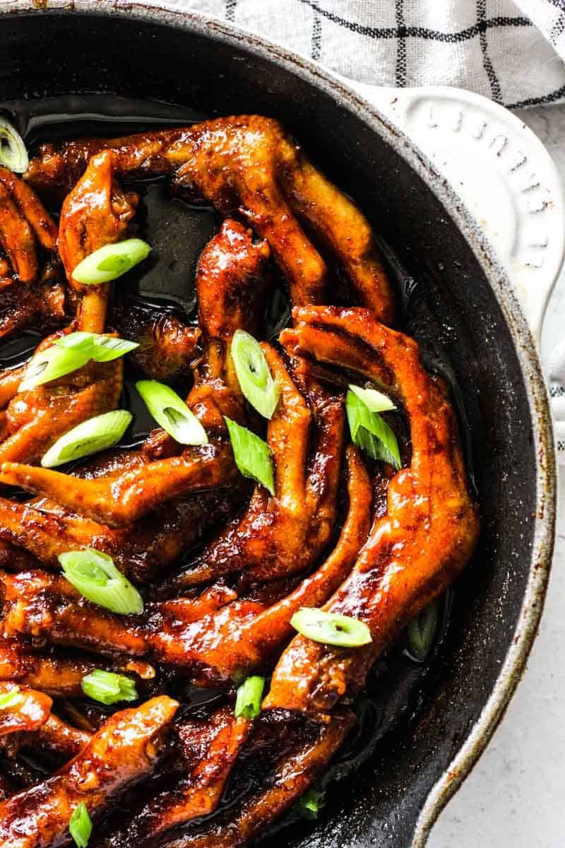 cooked duck feet in the Chinese sauce with chopped green onions on top