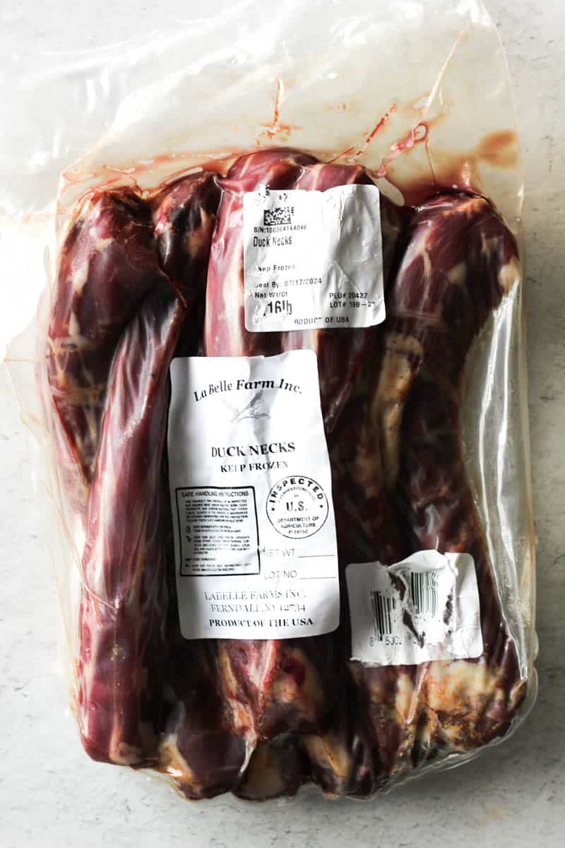 plastic package with raw duck necks on the table