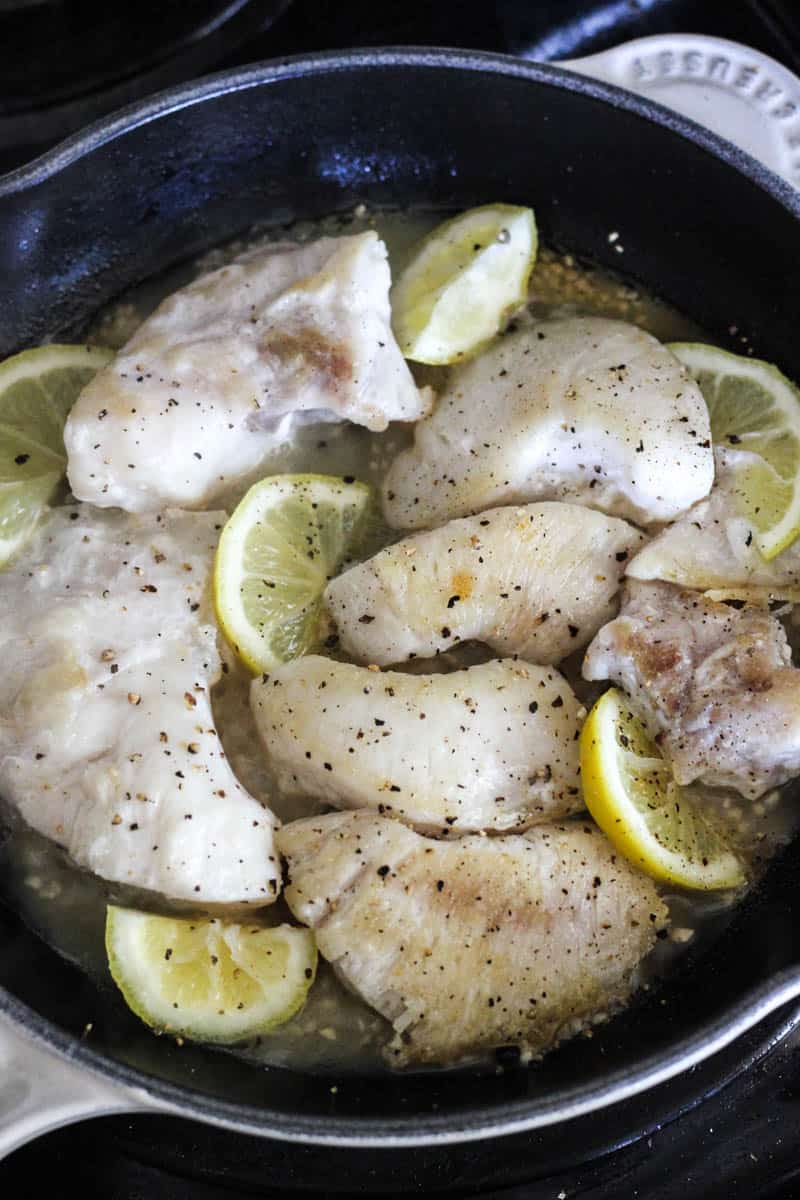 cooking fish in the skillet with lemon