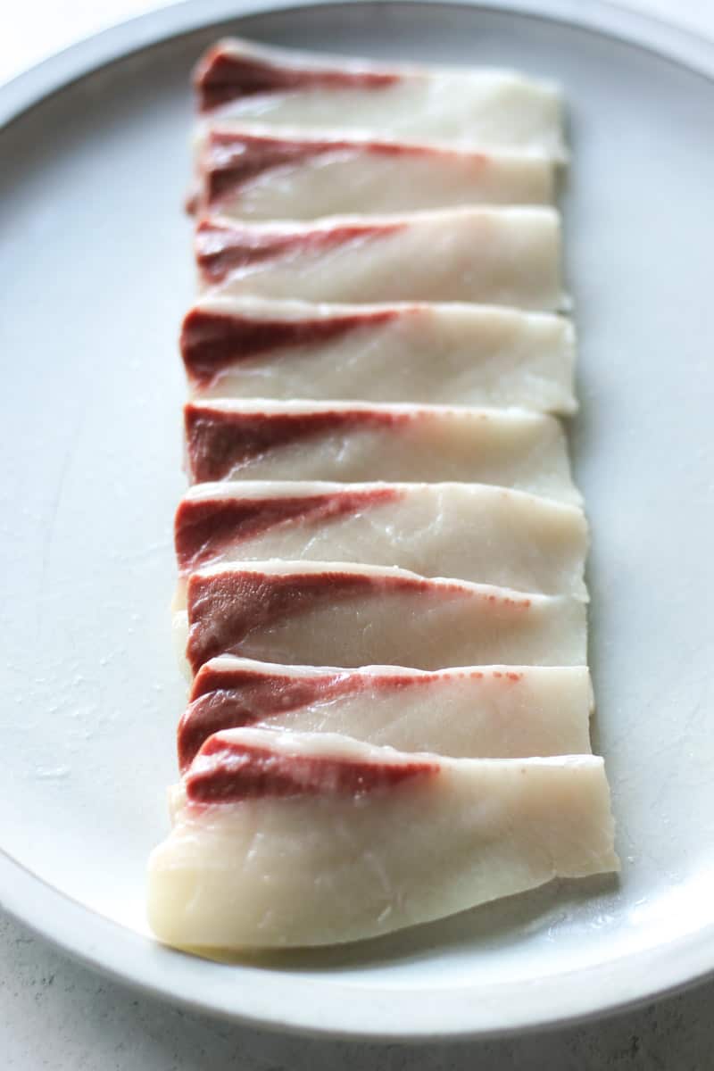 sliced white fish on the white plate