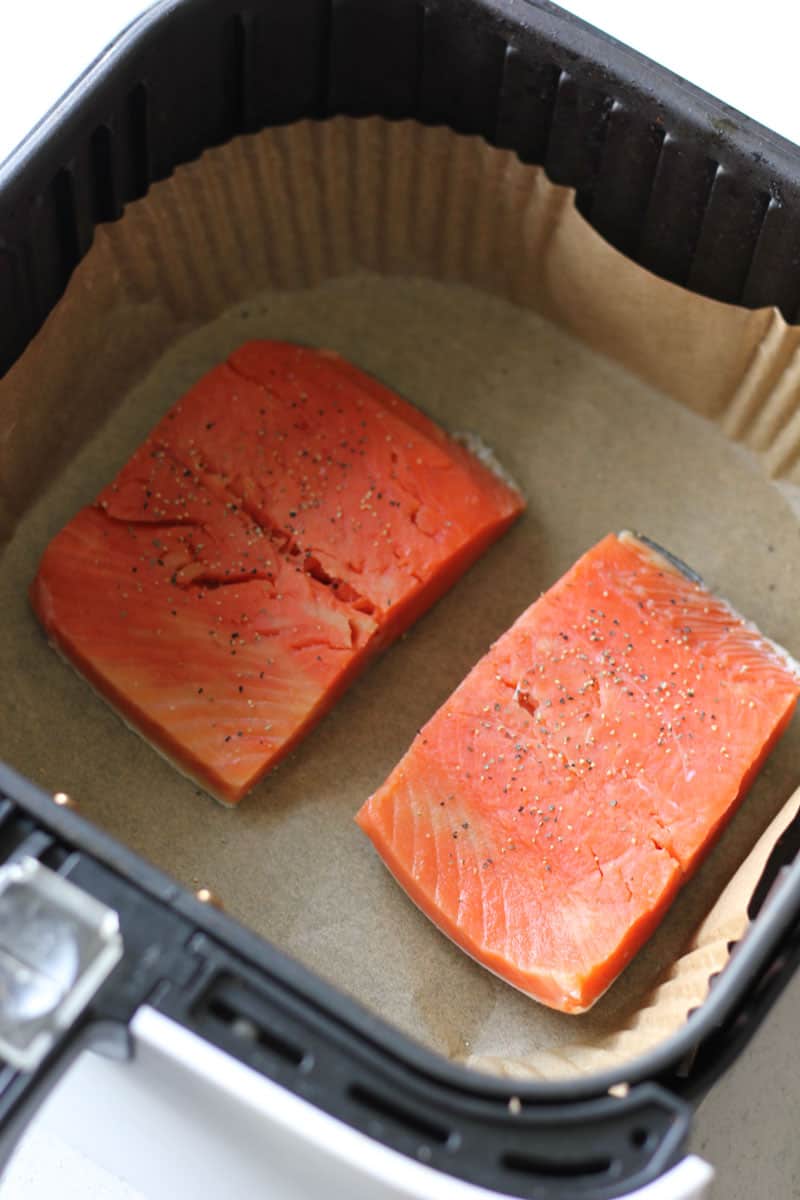 two raw salmon fillets in air fryer