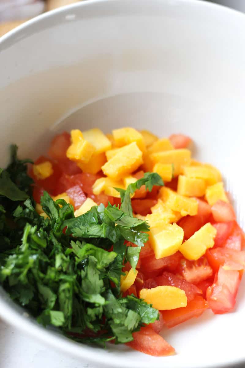 chopped cilantro, tomato and mango in the bowl