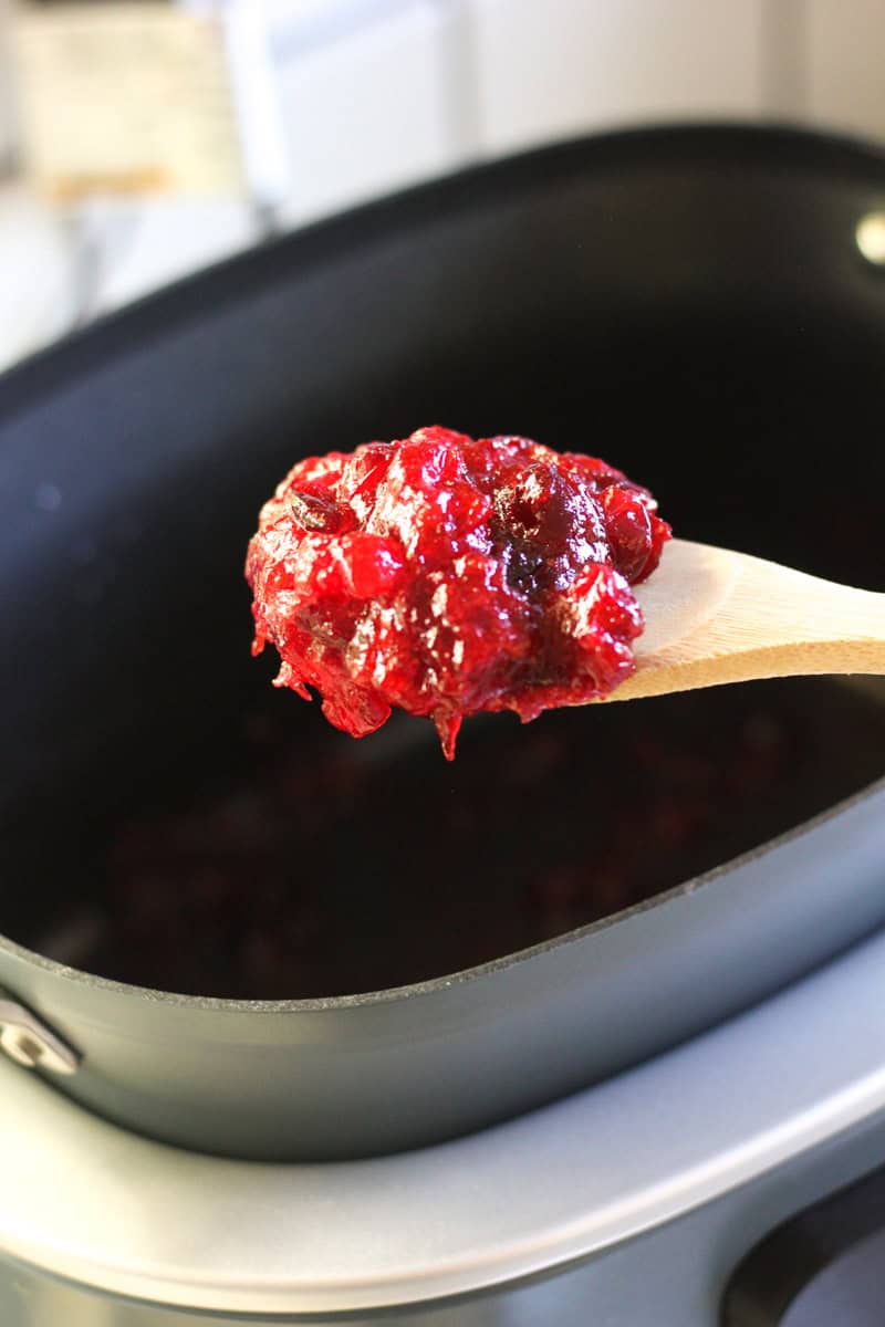 a scoop of cranberry sauce on wooden spatula