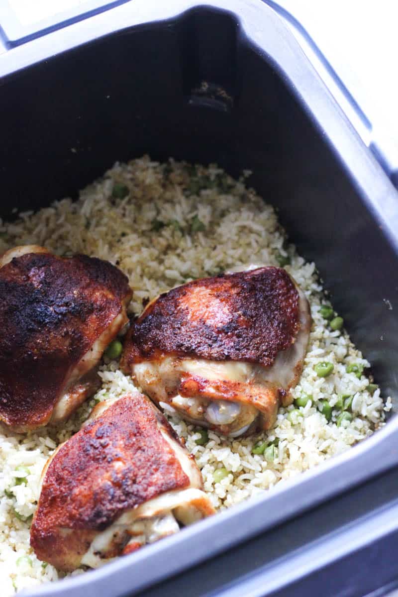 chicken thighs in ninja speedi on top of rice with green peas