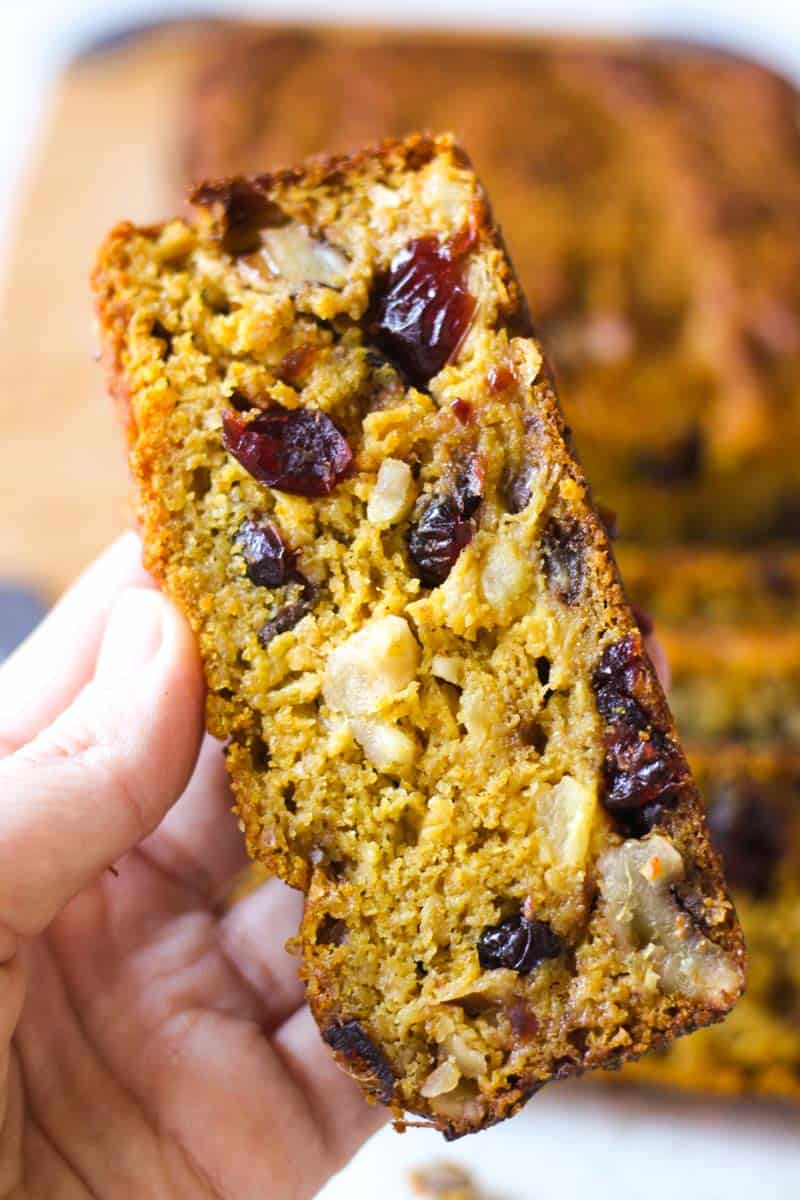 a slice of pumpkin fruitcake with pineapple in hand