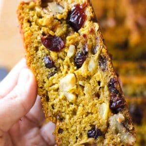 a slice of pumpkin fruitcake with pineapple in hand