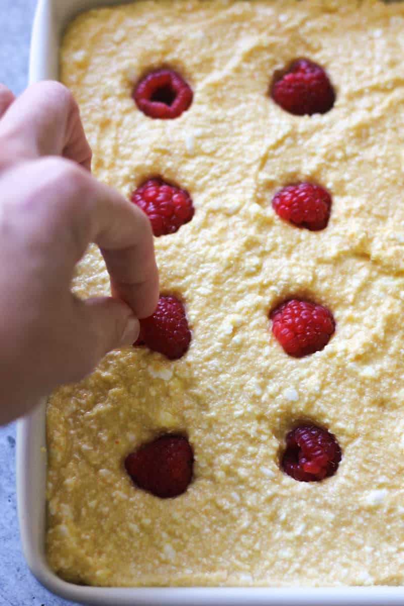 adding raspberries to the cake