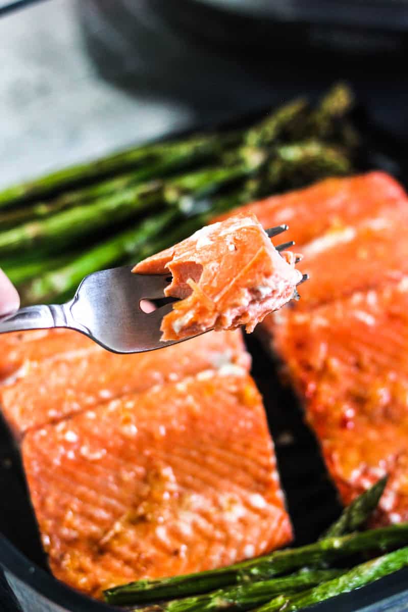 holding a fork with salmon piece on it