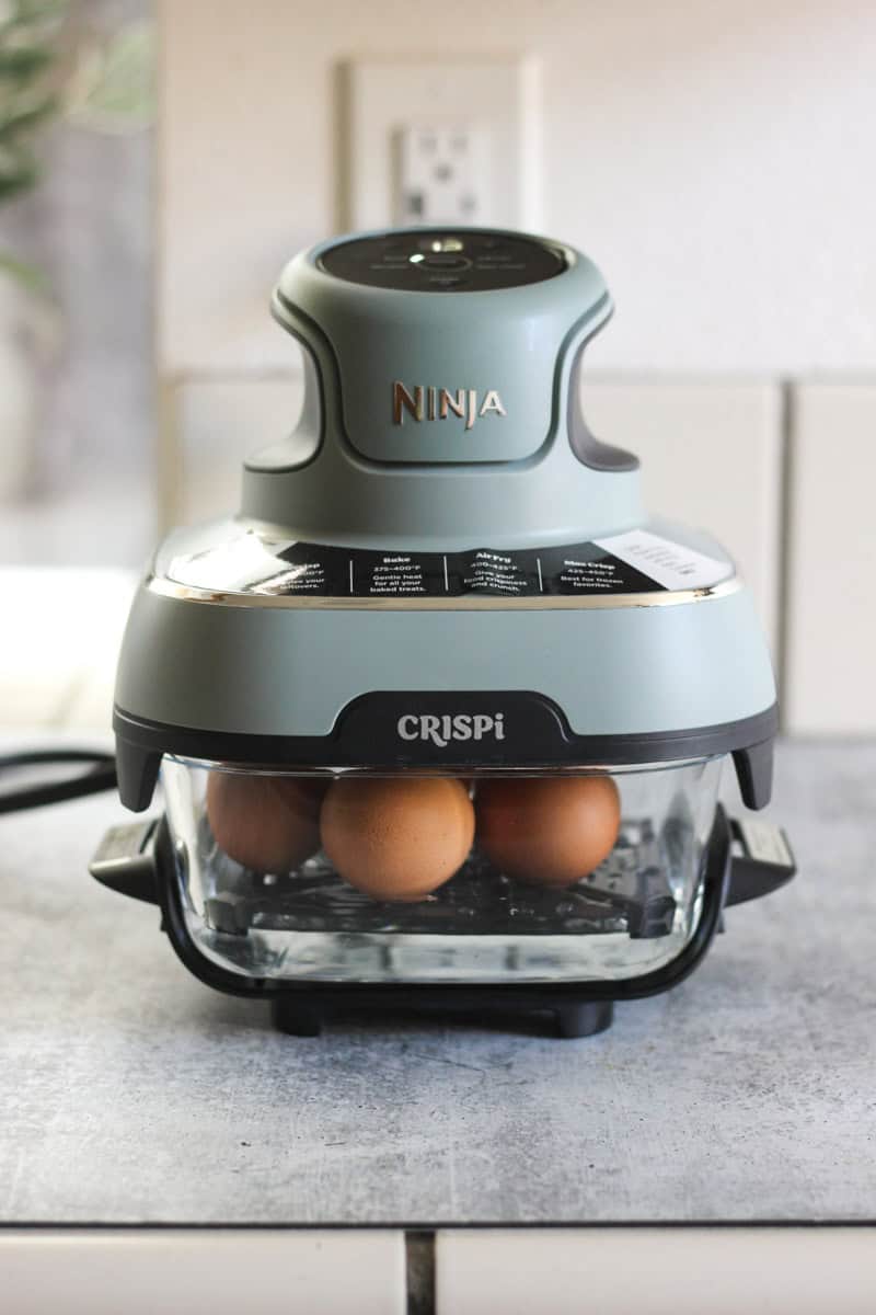 Ninja Egg Cooker with eggs in a modern kitchen setting.