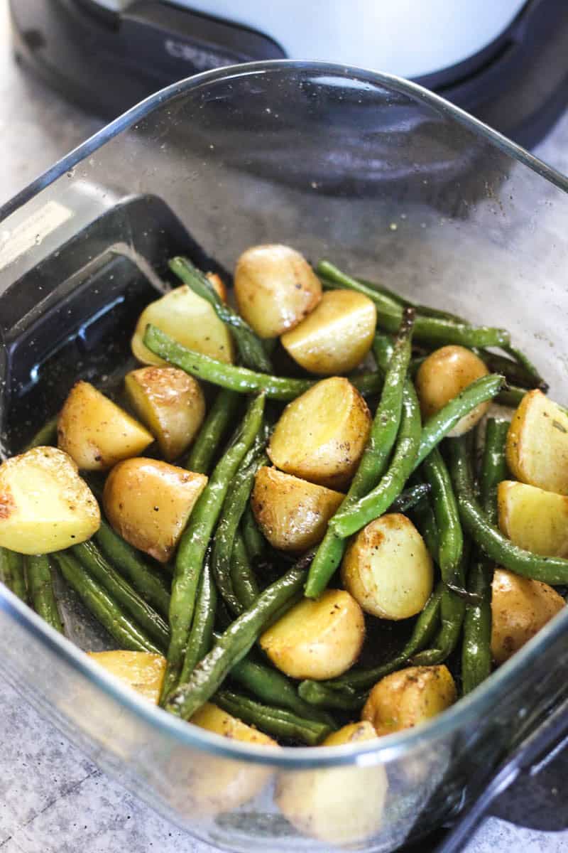 Baked potatoes and green beans in a glass dish for a healthy meal.
