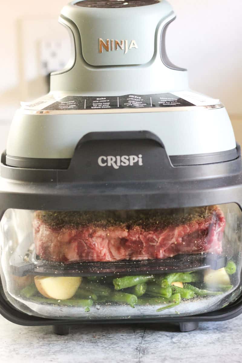 Crispi food processor with meat and vegetables inside, ready for cooking.