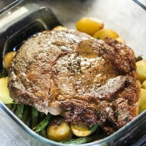 Juicy grilled steak served with potatoes and green beans in a black skillet.