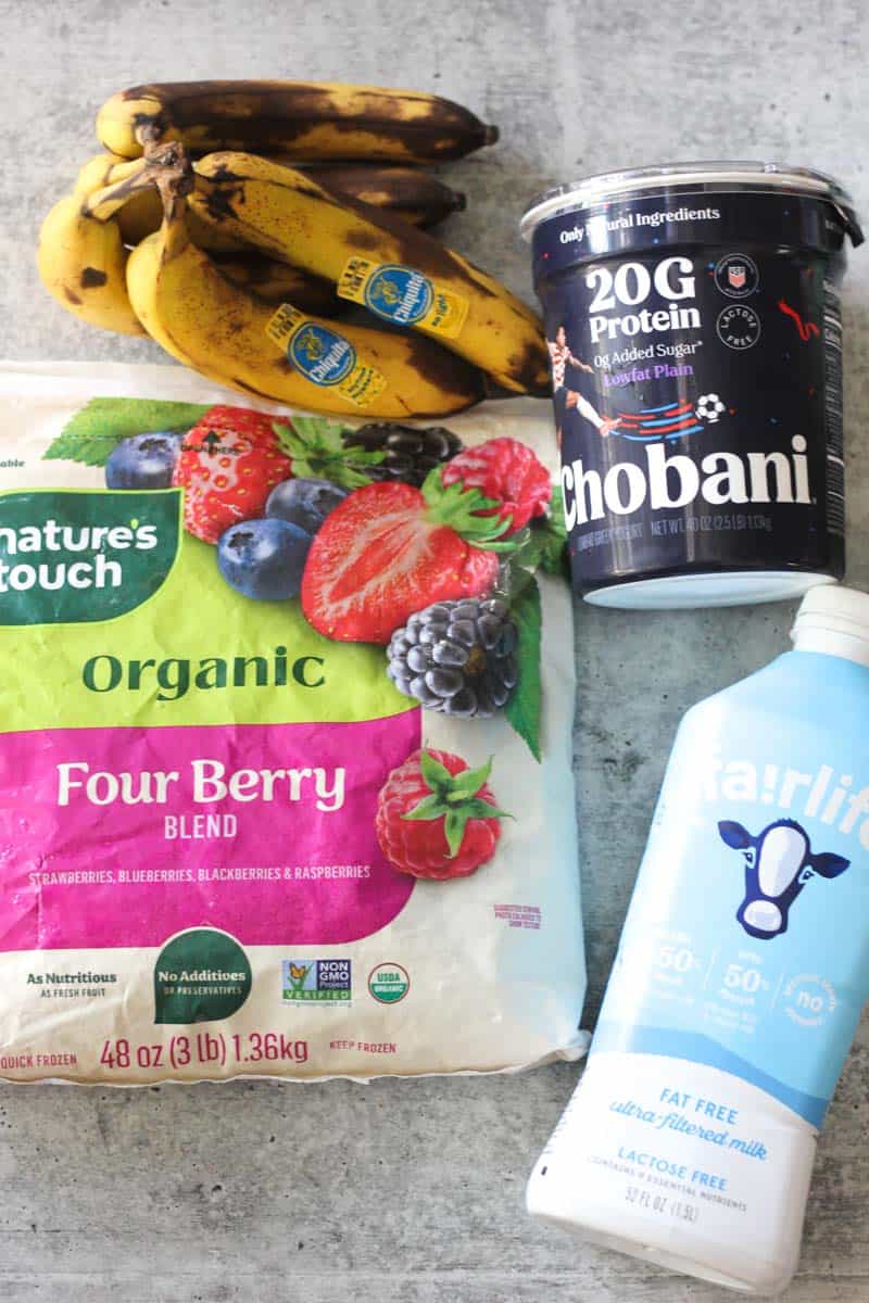 Bananas, organic berry blend, protein yogurt, and almond milk for smoothie.
