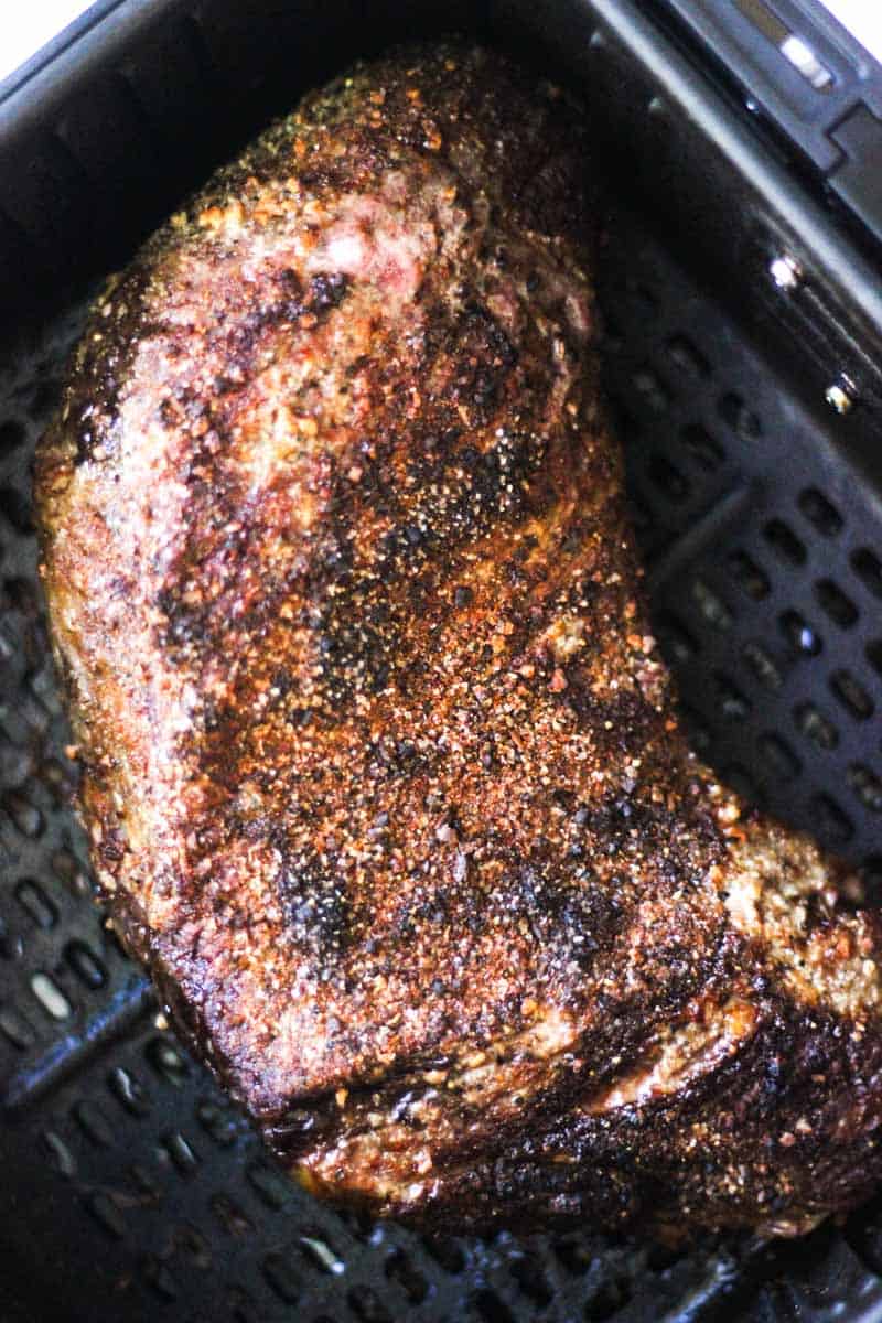 Succulent smoked beef brisket with dark bark in a smoker basket.