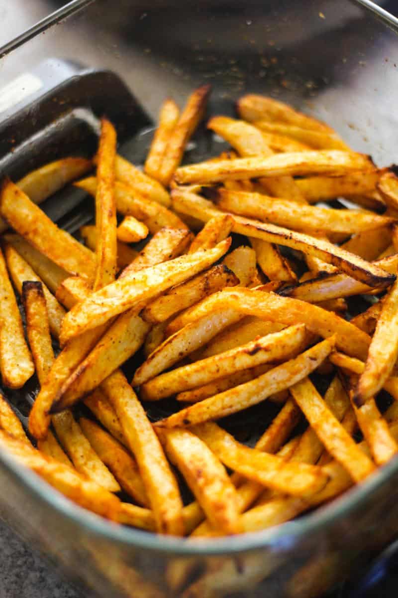Crispy seasoned french fries in a tray.