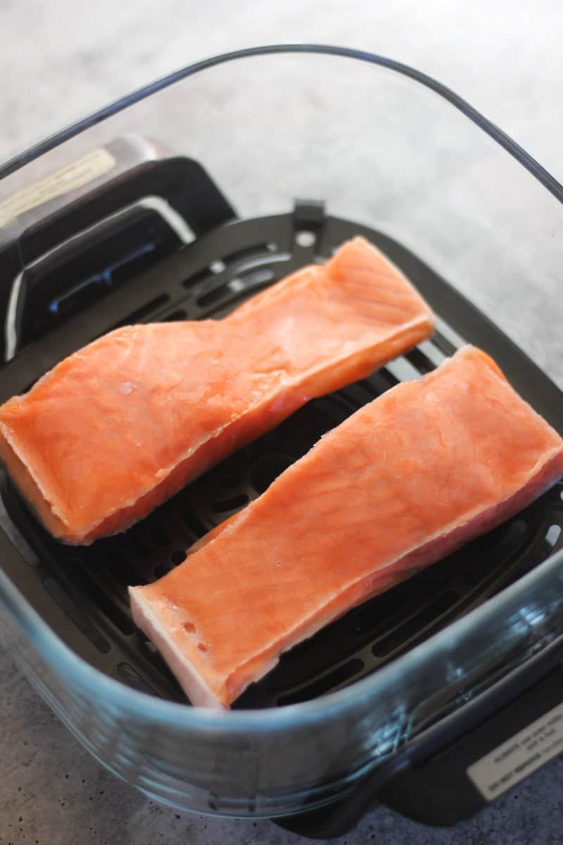 Salmon fillets cooking in an air fryer for a quick, healthy meal.