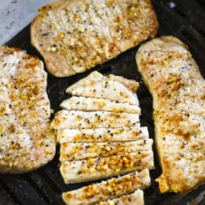 Grilled pork tenderloin with seasoned crust and pepper flakes.